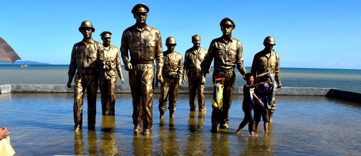 A group of men standing next to a body of water
Description automatically generated