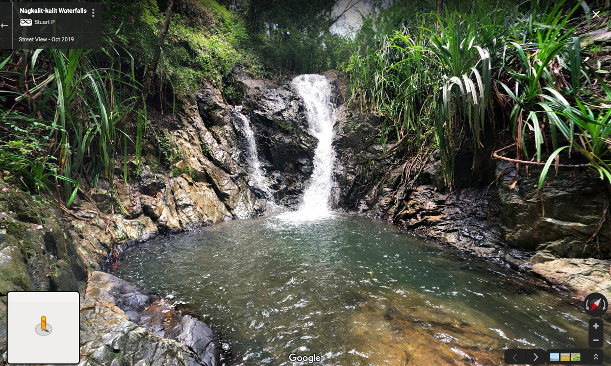 A person standing next to a waterfall
Description automatically generated